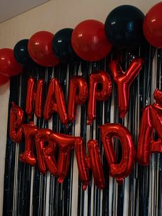 red and black balloons with the words happy birthday written on them in front of a wall