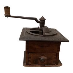 an old fashioned metal grinder with a handle on it's side and a white background