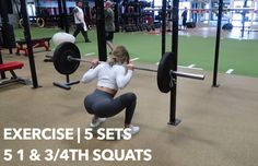 a woman squats on the ground while holding a barbell in front of her