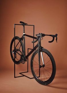 a bike is shown in front of a brown background with the frame leaning up against it