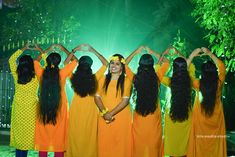 a group of women standing next to each other holding their hands up in the air