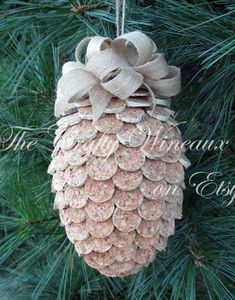 a pine cone ornament hanging from a christmas tree