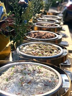 there are many different types of food in bowls on the table with people looking at them