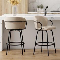 two stools sitting next to each other in front of a counter top with flowers on it