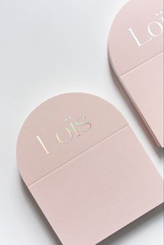 two pink business cards sitting on top of each other with the word lois printed on them