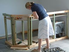 a woman standing on top of a hard wood floor in front of a wooden shelf