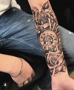 a man's arm with a clock and roses on it