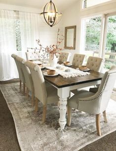 the dining room table is set with white chairs