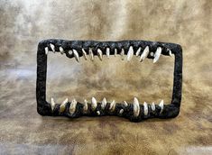 a black metal object with teeth on it's side sitting on a brown surface