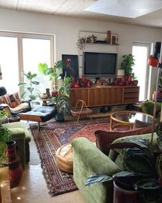 a living room filled with lots of furniture and plants