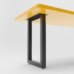 a yellow and black table with two metal legs on the top, in front of a white background