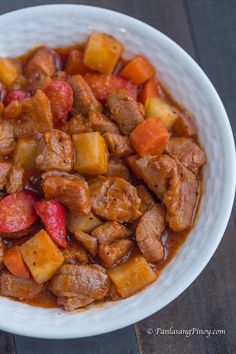 a white bowl filled with meat and vegetables