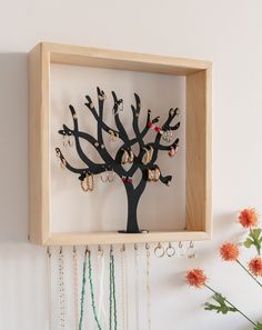 a wooden frame holding a tree with earrings on it