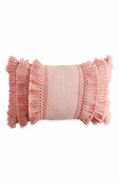 a pink pillow with fringes on it