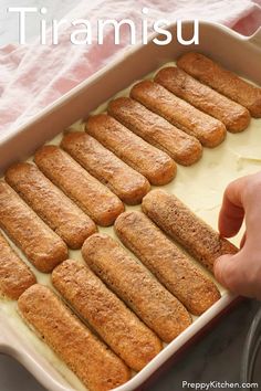 someone is placing some bread sticks in the casserole dish with cream cheese on top