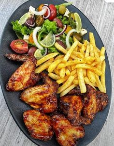 a plate with chicken, french fries and salad on the side is ready to be eaten