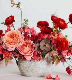 a vase filled with lots of red and pink flowers