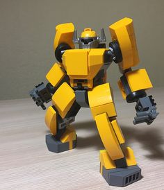 a yellow and black lego robot on a table