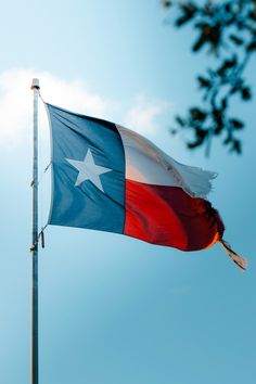 the texas flag is flying high in the sky