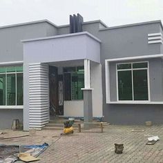 a grey house with white trim on the front and side windows, in an area that is under construction