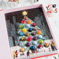 a christmas tree made out of marbles in a pink box