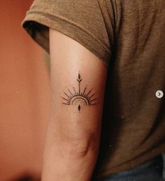 a woman's arm with a tattoo on it and an arrow in the middle