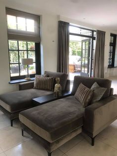 a living room filled with furniture and large windows