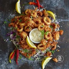 fried shrimp and vegetables on a plate with dipping sauce