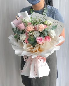 a woman holding a bouquet of flowers with a note attached to her head and an envelope in front of her face