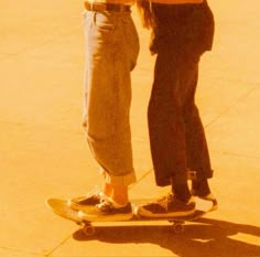 two people are standing on a skateboard and one is holding onto another person's leg