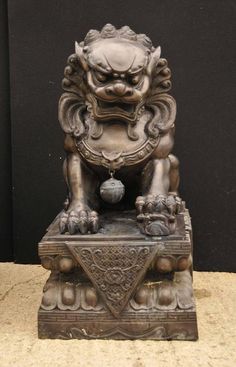 a bronze lion statue sitting on top of a table