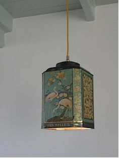 a lamp hanging from the ceiling in a room with a painting on it's side