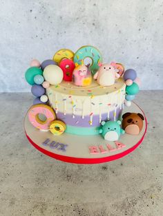 a birthday cake decorated with donuts, balloons, and other items on a plate