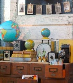 an old dresser is filled with books and other items, including a globe on top