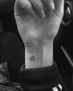 a small heart tattoo on the wrist