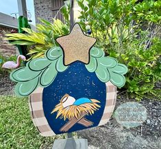 a nativity scene with a star on top and a bird in the middle, surrounded by greenery