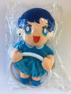 a stuffed animal with blue hair holding a steering wheel