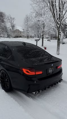 a black car is parked in the snow