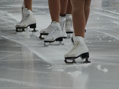 several people are skating on ice with their feet in the air