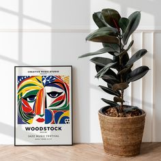 a plant in a pot next to a poster on the wall that says woodstock