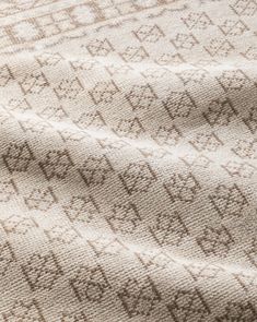 a close up view of a blanket with brown and white designs on it's fabric