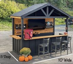 an outdoor bar with stools next to it and a television on the top shelf