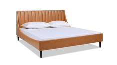 an image of a bed with white pillows and brown leather headboard on the side