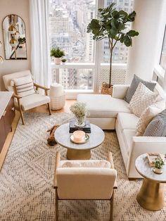 a living room filled with furniture and a large window overlooking the cityscape in the background