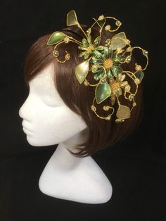 Green floral fascinator vine perfect for the guest or bride who is looking for a beautiful bespoke design. This design is a beautiful selection of glass effect leaves and flowers teamed with crystal swirls and set onto a gold ribbon base tiara band. As with all our designs, this piece can be made exact to the image or in any colour combination to match in with your outfit. If a specific colour is required customers can message over an image of their outfit and accessories, or if time allows cust Green Fascinator With Handmade Flowers For Party, Flower Decorated Headband For Party, Floral Decorated Headband For Party, Floral Decoration Headband For Party, Green Handmade Flowers Wedding Fascinator, Elegant Green Hair Accessories For Wedding, Green Headband Fascinator For Wedding, Green Wedding Headband Hair Accessory, Green Headband For Wedding