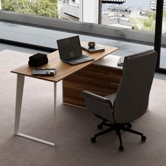 an office desk with a laptop on it in front of a window overlooking the city