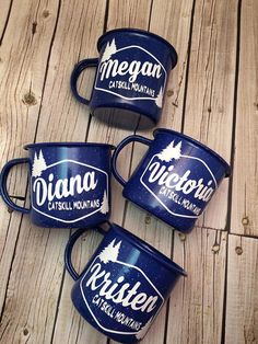 four blue coffee mugs sitting on top of a wooden table