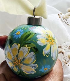 a hand painted ornament in the shape of a ball with flowers on it