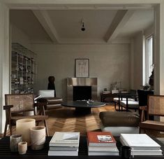 a living room filled with lots of furniture and books on top of a coffee table