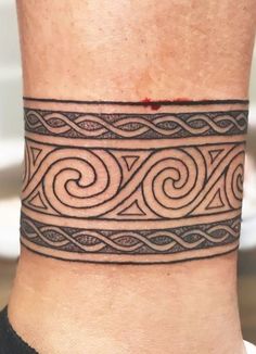 a man with a tattoo on his ankle that has a spiral design in the middle